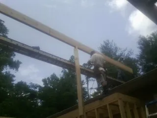 Carpenter setting a ridge beam over a new addition frame — Ice Dam Removal by Roofing Brothers in Moorhead