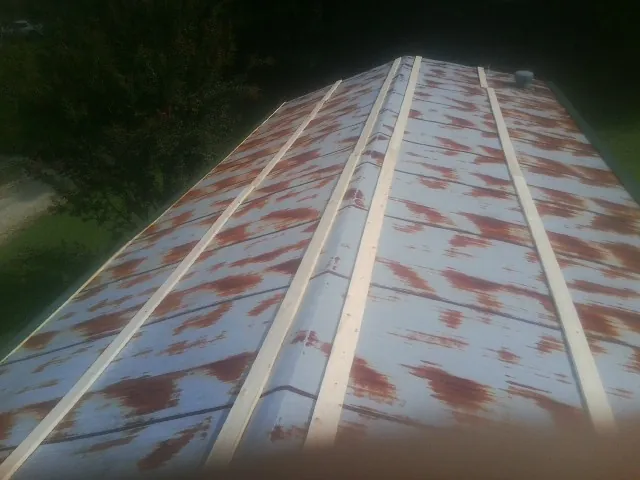Rusted metal roof panels with new wood purlins before replacement — Storm Damage Roof Repair in Moorhead by Roofing Brothers